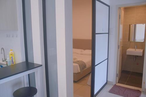 a room with a bathroom with a bed and a mirror at Home Sweet 2 bedrooms with Free WiFi Midhill Genting 9pax in Genting Highlands