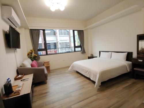a hotel room with a bed and a couch at JINGTONGYULI BnB 民宿編號2415 in Yuli