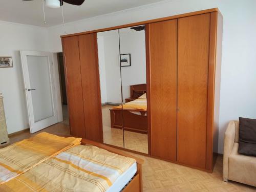 a bedroom with a large wooden closet with a mirror at Apartment Hernals in Vienna