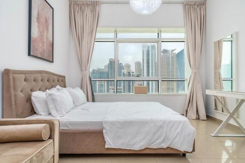 sypialnia z łóżkiem i dużym oknem w obiekcie skynest homes studio in JLT w Dubaju