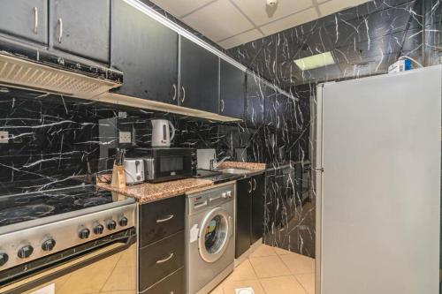 kuchnia z kuchenką i pralką w obiekcie skynest homes studio in JLT w Dubaju