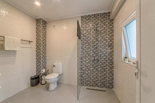 a bathroom with a toilet and a glass shower at Mountain View Lodge Bulgaria in Ranentsi