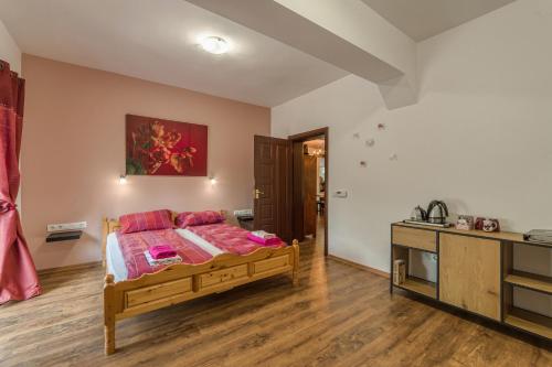 a bedroom with a bed with pink pillows on it at Mountain View Lodge Bulgaria in Ranentsi
