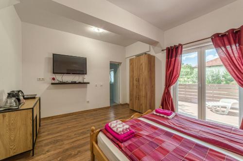 a bedroom with a bed and a tv on the wall at Mountain View Lodge Bulgaria in Ranentsi