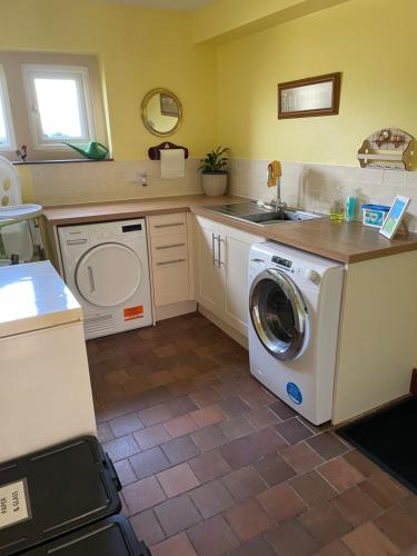 Il comprend une cuisine équipée d'un lave-linge et d'un évier. dans l'établissement Cotswolds Luxury House in Central Bourton Large Sleeps 2-11. Pet Friendly., à Bourton-on-the-Water