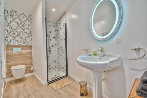 een witte badkamer met een wastafel en een douche bij ALiCe Au PaYs dEs MerVeiLLeS in Maintenon
