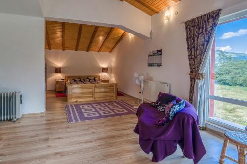 a bedroom with a bed and a large window at Mountain View Lodge Bulgaria in Ranentsi