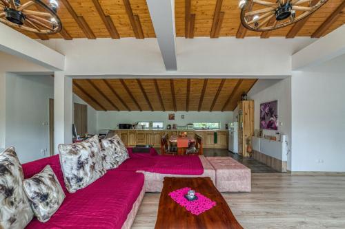 a living room with a red couch and a table at Mountain View Lodge Bulgaria in Ranentsi