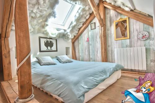 een slaapkamer met een bed in een kamer met een plafond bij ALiCe Au PaYs dEs MerVeiLLeS in Maintenon