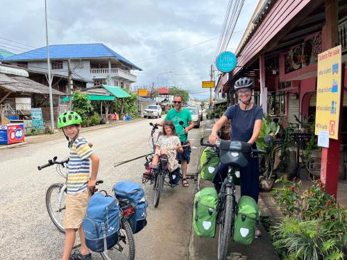 un gruppo di persone che vanno in bicicletta lungo la strada di Little Hostel a Ban Houayxay