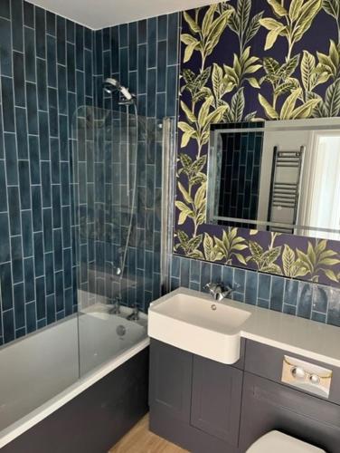 a bathroom with a sink and a tub and a mirror at Redwing- free parking- Grade II listed- ground floor two bedrooms apartment in Huntingdon