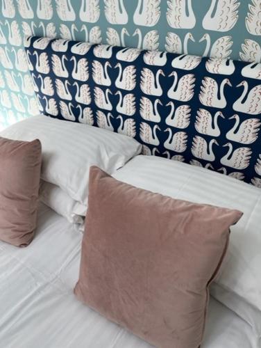 a white bed with two pillows and a wall at Redwing- free parking- Grade II listed- ground floor two bedrooms apartment in Huntingdon