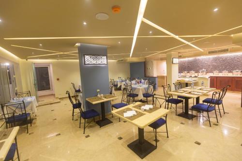 Un restaurante con mesas y sillas en una sala. en Swiss Wellness Dive Resort, en Hurghada