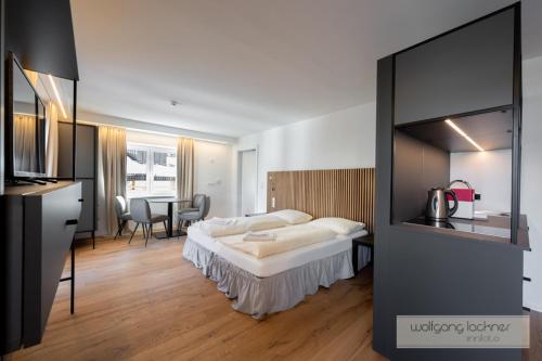 a hotel room with a bed and a dining room at Appartements zur Sonne in Neustift im Stubaital