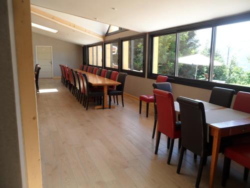 a dining room with tables and chairs and windows at GITE AUBERGE EDELWEISS in Seyssel