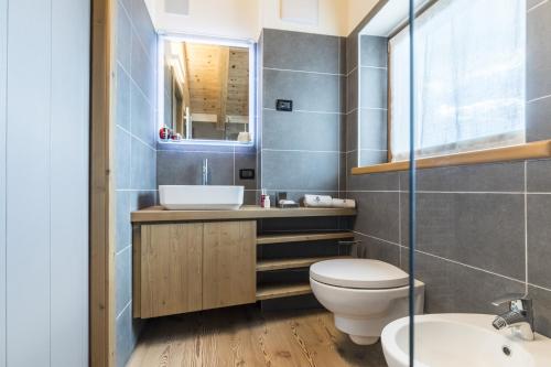 a bathroom with a toilet and a sink and a mirror at Folgaria Top Rent in Folgaria