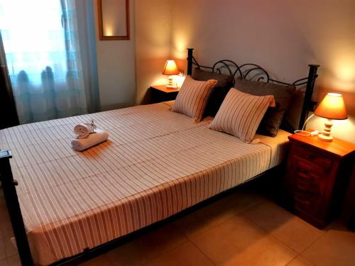 a bed with a pair of shoes sitting on it at Seaside mountain view Golden Mar villa in Paránimfoi