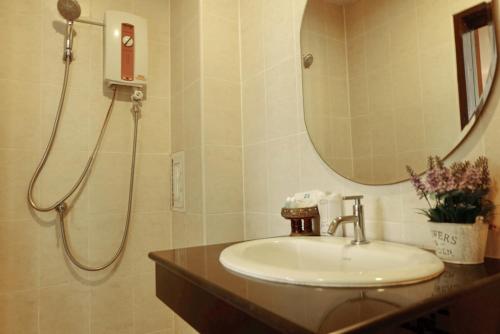 a bathroom with a sink and a shower with a mirror at Calypso Patong House in Patong Beach