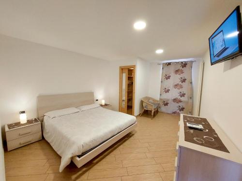 a bedroom with a bed and a flat screen tv at Appartamento Diana in Cavalese