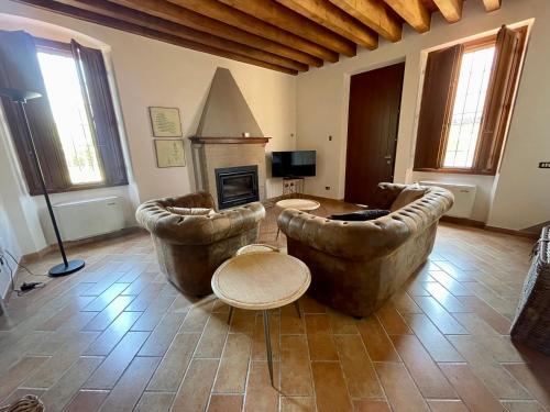 uma sala de estar com dois sofás grandes e uma lareira em Agriturismo Boschetto em Boschetto