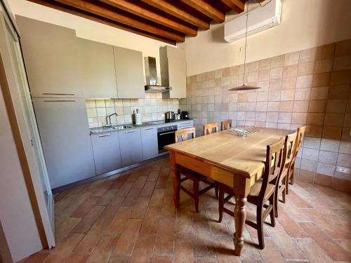 uma cozinha com uma mesa de madeira e cadeiras em Agriturismo Boschetto em Boschetto