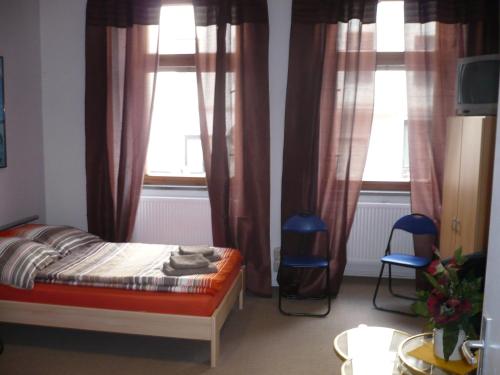 a bedroom with a bed and two windows at Apartment Jannowitzbrücke in Berlin
