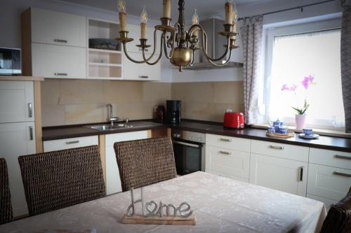 a kitchen with a table and chairs and a chandelier at Ferienhaus Schneckenheisl in Mindelstetten