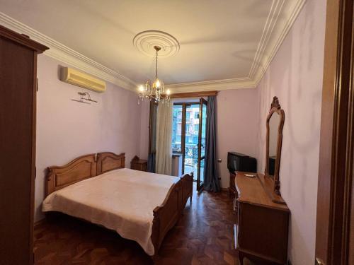 a bedroom with a bed and a television in it at Guesthouse Parnavaz Mepe in Batumi