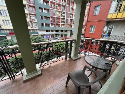 a balcony with a table and chairs and buildings at Guesthouse Parnavaz Mepe in Batumi