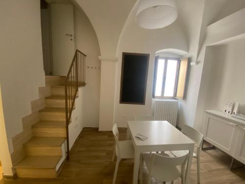 a dining room with a table and a staircase at La Chianca in Putignano