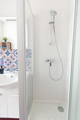 une douche avec une porte vitrée à côté d'un lavabo dans l'établissement Appartement 2 pièces chic et cosy à Paris, à Gentilly