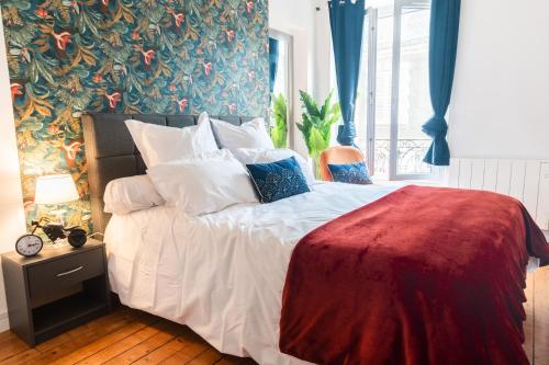 une chambre avec un lit avec des draps blancs et des oreillers dans l'établissement Appartement 2 pièces chic et cosy à Paris, à Gentilly