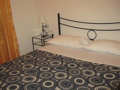 a bedroom with a bed with a black and white comforter at La Casetta Arancione appartamento in Stroncone