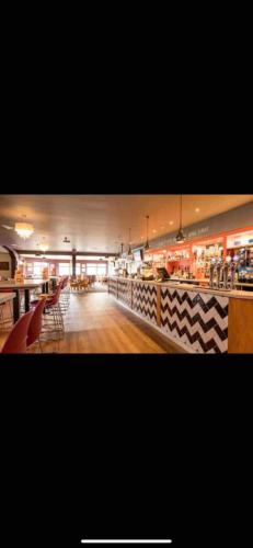a restaurant with tables and chairs and a counter at Yogi's Space in Birchington