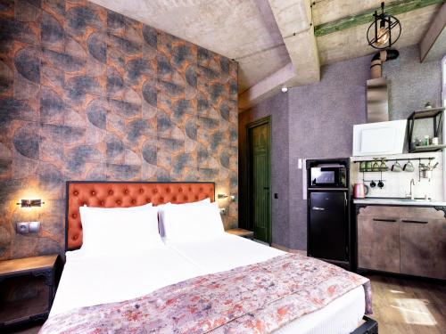 1 dormitorio con cama y pared en 6 Unique Apartments en Tiflis