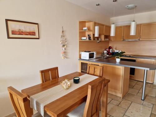 uma cozinha com uma mesa de madeira e uma cozinha com um balcão em HC Apartments Kaliakria em Topola