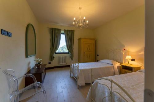 Habitación de hotel con 2 camas y lámpara de araña. en La Limonaia, en Colle di Buggiano