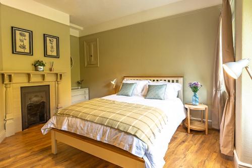 a bedroom with a bed and a fireplace at Cosy cottage in the heart of Bakewell in Bakewell