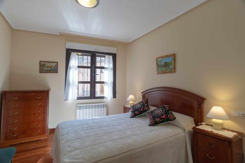 a bedroom with a bed with a dresser and a window at El Jardín de Fray Diego in Zamora