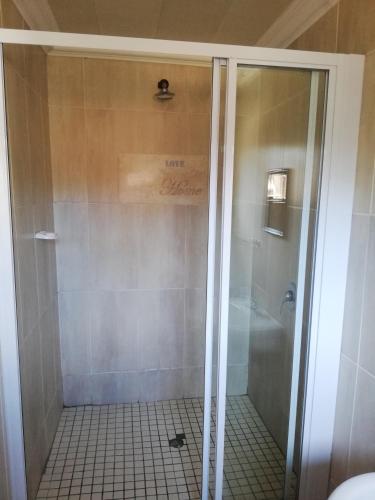 y baño con ducha y puerta de cristal. en Nonesi Lodge, en Queenstown