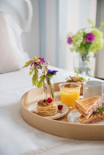 a tray of food with pancakes and a plate of orange juice at Hotel Villa Rosa Riviera in Rimini