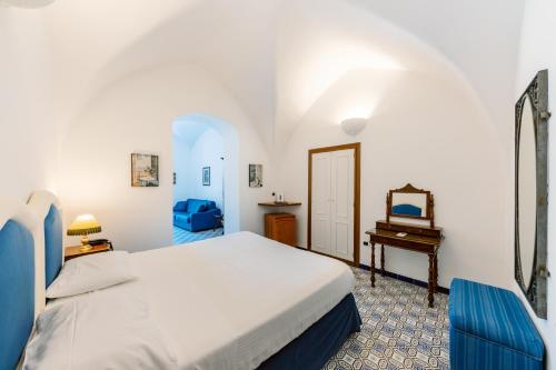 1 dormitorio con cama, mesa y espejo en Hotel Giordano, en Ravello