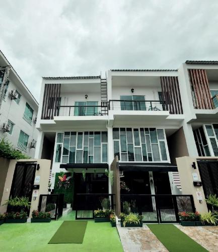 a large white building with a green courtyard at Boxsoon Nimman 4 # 3beds 4baths in Chiang Mai