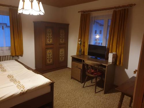 sypialnia z łóżkiem i biurkiem z telewizorem w obiekcie Haus Waldhuber w mieście Schwoich