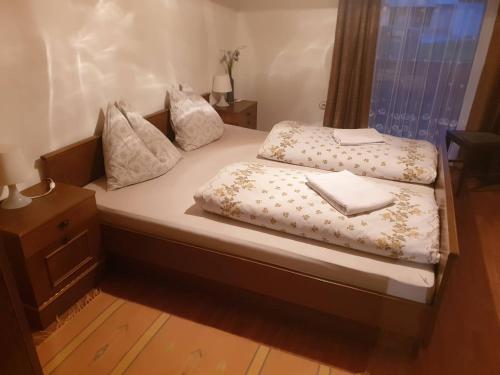 a bed with white sheets and pillows on it at Haus Waldhuber in Schwoich