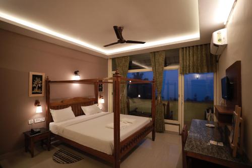 a bedroom with a canopy bed and a window at Green Valley Vista in Munnar