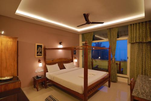 a bedroom with a canopy bed and a window at Green Valley Vista in Munnar