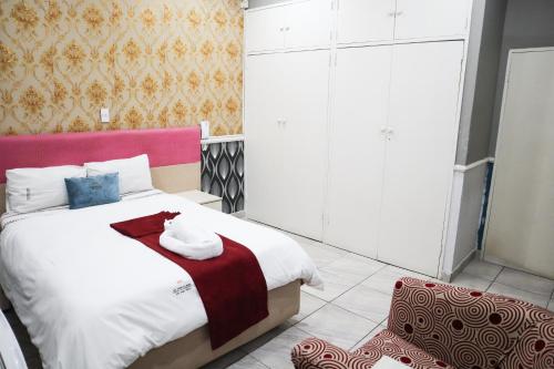 a bedroom with a large bed with a red headboard at Gold Crown International Hotel With Complementary Breakfast and WiFi in Johannesburg