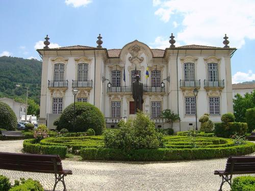 Quinta do Cabril في Serpins: مبنى فيه تمثال في وسط حديقة