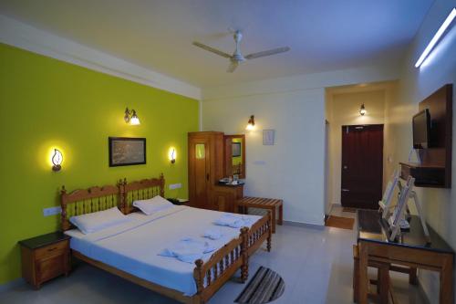 1 dormitorio con cama y pared verde en Green Valley Vista, en Munnar